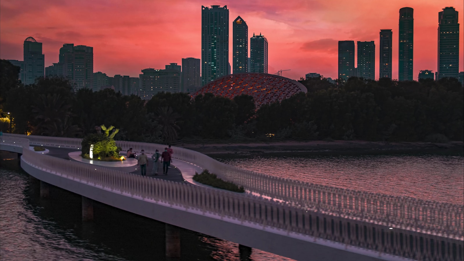 Al Noor Island bridge with Sharjah cityscape at sunset