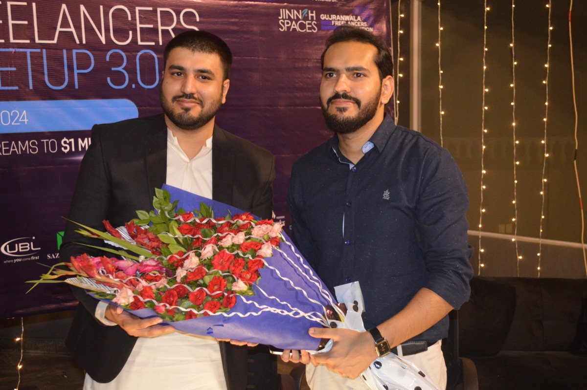 Zain Saeed at the Gujranwala Freelancers Meetup 3.0 event receiving a bouquet