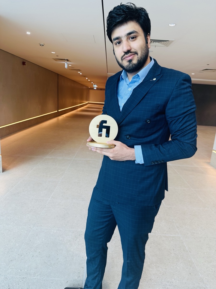 Zain Saeed standing with the Fiverr Millionaire Award trophy