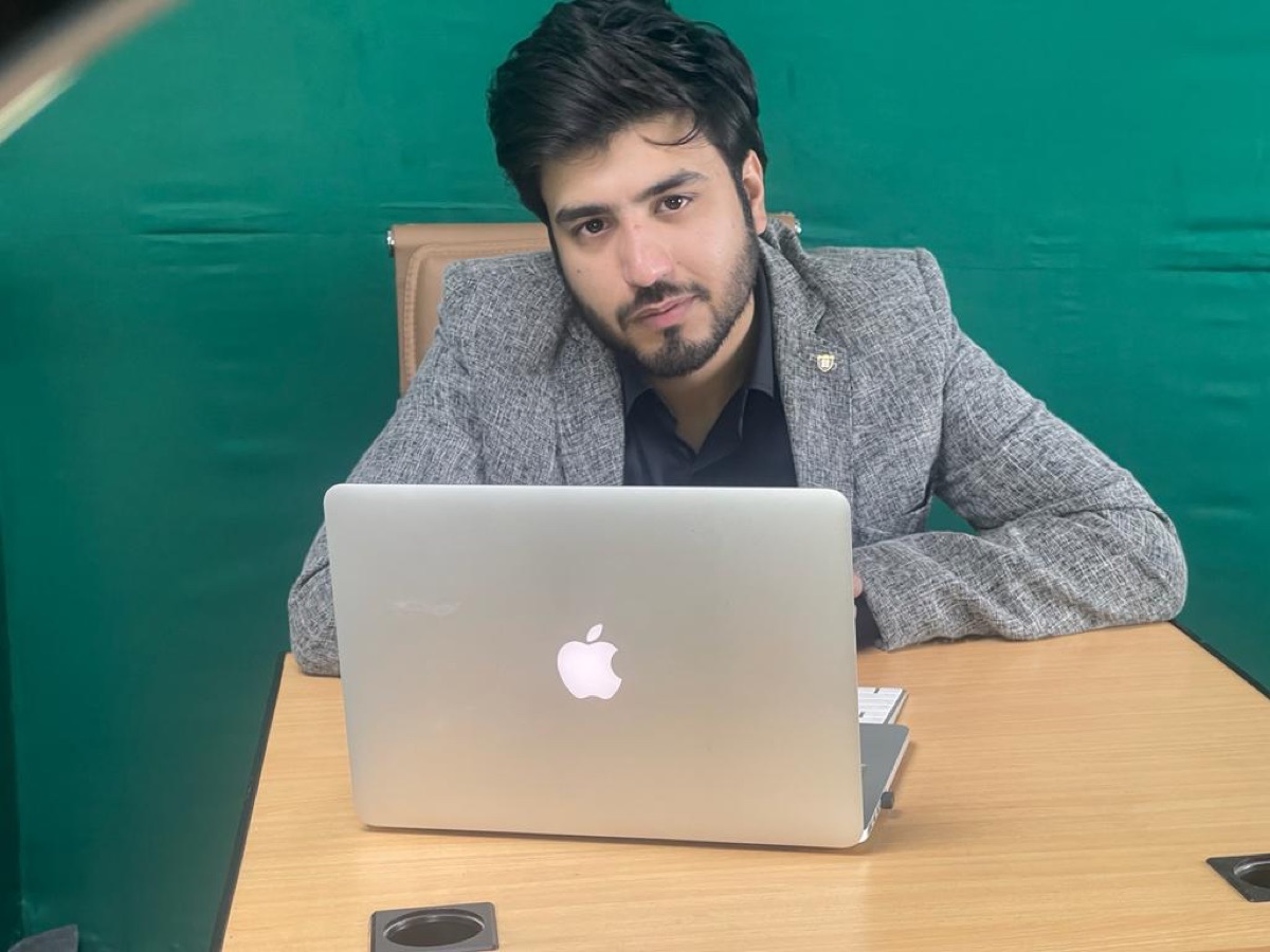 Zain Saeed working at his desk with a MacBook